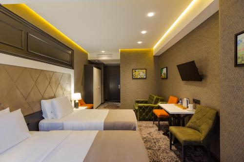 a hotel room with two beds and a table at Tapis Rouge Design Boutique Hotel in Batumi