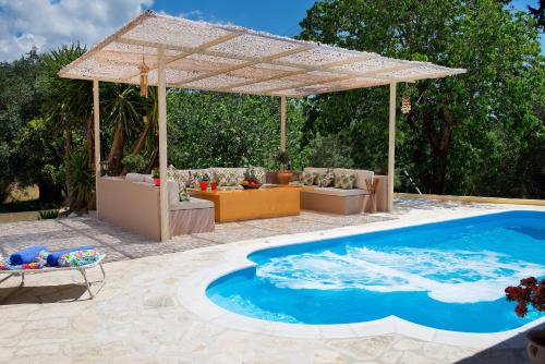 a patio with a swimming pool and a pergola at Da Sofia in Pelekas