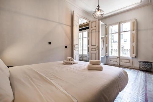 a bedroom with a large white bed with towels on it at eg21- MODERNIST AND ELEGANT APARTMENT IN BCN CITY CENTER in Barcelona