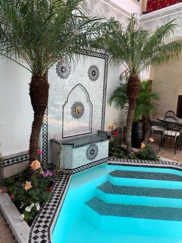 a swimming pool with palm trees in a room at Riad Abaka hotel & boutique in Marrakech