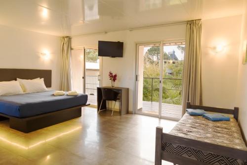 um quarto de hotel com uma cama e uma varanda em Undarius Hotel (exclusively gay men) em Punta del Este