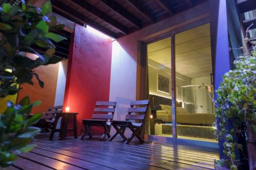 a patio with chairs and a table and a bedroom at Undarius Hotel (exclusively gay men) in Punta del Este