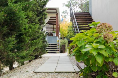 a garden with a walkway leading up to a house at Undarius Hotel (exclusively gay men) in Punta del Este