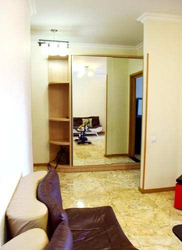 a living room with a couch and a mirror at tbilisi tower 3 in Tbilisi City