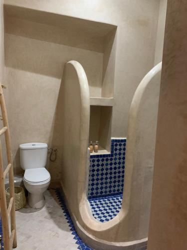 a bathroom with a toilet and a blue tile floor at Riad Abaka hotel & boutique in Marrakech
