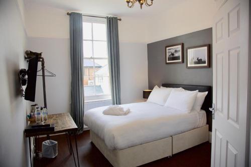 a bedroom with a white bed and a window at The Mortimer Arms in Romsey