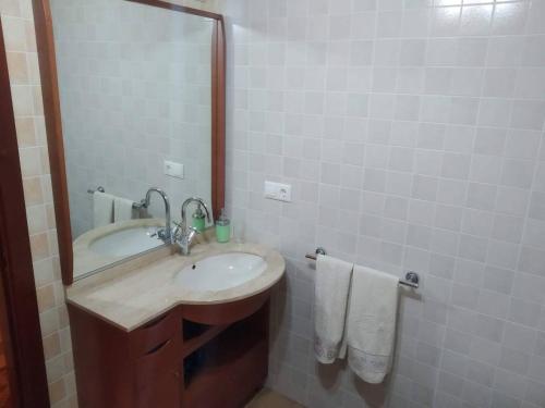 łazienka z umywalką i lustrem w obiekcie Apartamento La Real w mieście Caldas de Reis