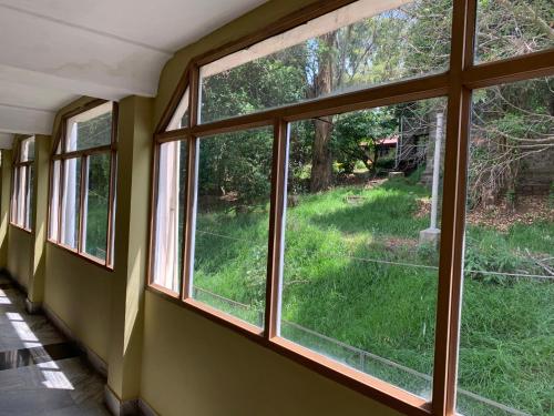 a room with windows with a view of a yard at Hotel Jc Grand in Kodaikānāl