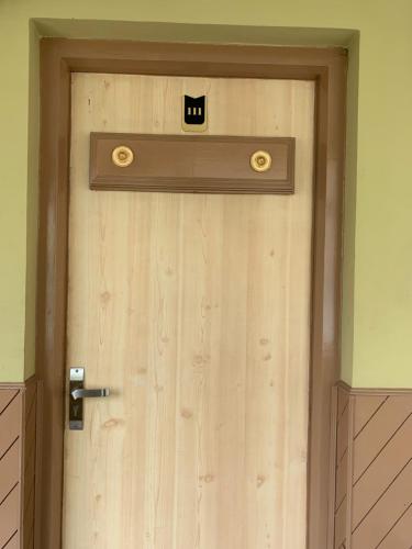 a wooden door with a cat face on it at Hotel Jc Grand in Kodaikānāl