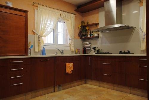 a kitchen with wooden cabinets and a sink and a window at Villa Magnolia in Mataró