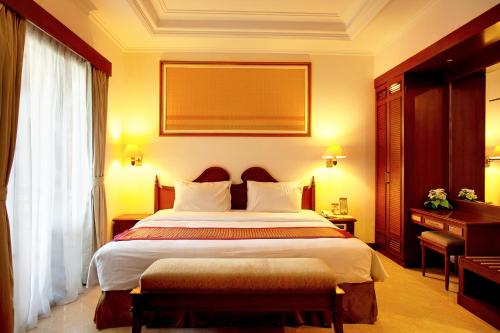 a hotel room with a large bed and a window at Le Dian Hotel in Serang