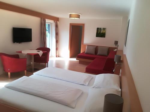 a hotel room with two beds and a couch at Haus am See in Fuschl am See