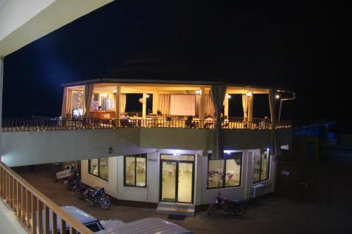 a house with a balcony at night with motorcycles on it at Paloma Guest House in Kenema