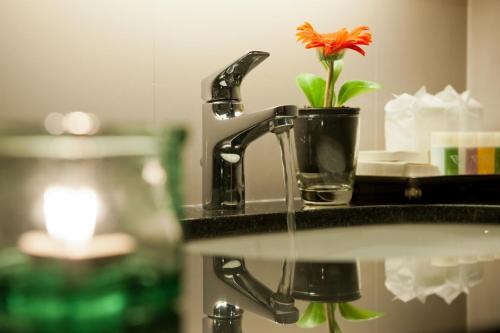 a bathroom sink with a flower in a glass at 41 Suite Bangkok in Bangkok