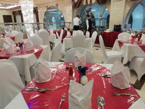 a banquet hall with white tables and white chairs at Mirage Al Salam Hotel in Medina