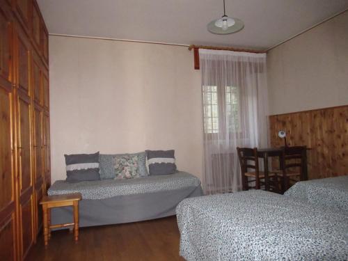 Brissogne的住宿－Maison Fiou，一间卧室设有两张床、一张沙发和一个窗口