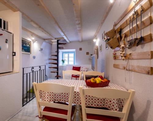 a kitchen and dining room with a table and chairs at Apartman Valdi in Baška