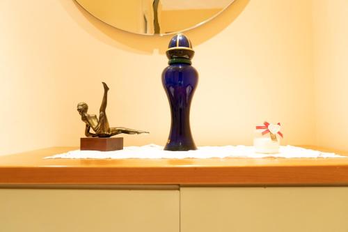 a shelf with a blue vase and a statue on it at Villa Lucia in Castellammare di Stabia