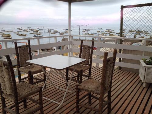 a table and chairs on a deck with a view of the ocean at Muelle Apart Hotel in Tongoy