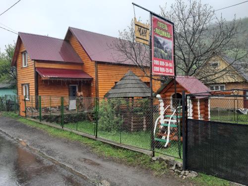 a building with a sign in front of a fence at Готель Людмила in Synevyr