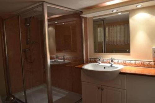 a bathroom with two sinks and a shower at Pat's Cottage in Sheffield