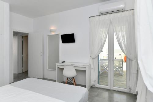 a bedroom with a bed and a desk and a window at Efi Studios in Drios
