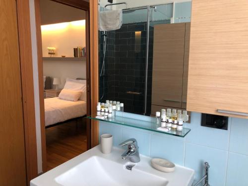 uma casa de banho com um lavatório, um espelho e uma cama em Bnbook-Tommaso Grossi Rho Fiera em Rho