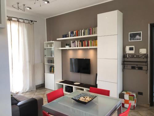 uma sala de estar com uma mesa e cadeiras vermelhas em Bnbook-Tommaso Grossi Rho Fiera em Rho