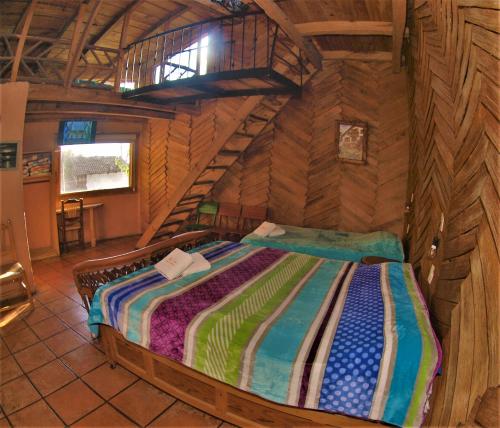 a bedroom in a log cabin with a bed at Hotel Cabaña Los Ruiseñores in Mazamitla