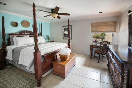 a bedroom with a bed with a ceiling fan and a desk at Beachfront At Crystal Cove in East End