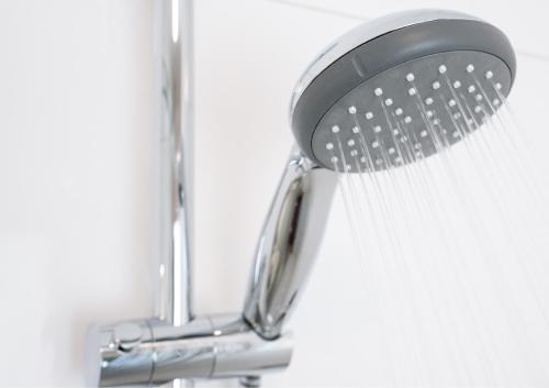a shower head with a brush in a bathroom at Hotel Post Sindelfingen in Sindelfingen