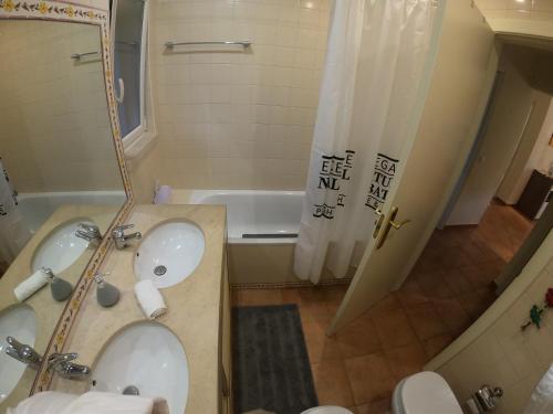 a bathroom with a tub and a sink and a shower at Golf & Beach Apartment in Charneca