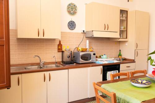 a kitchen with white cabinets and a microwave at B&B Favignana in Favignana