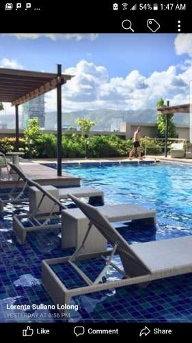 a picture of a swimming pool with a man walking in the water at KC Studio 1 at Horizons 101 Cebu in Cebu City