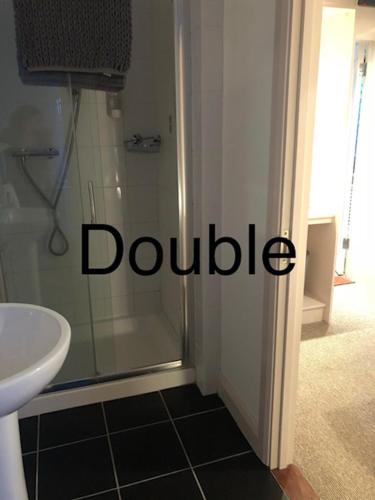 a bathroom with a shower with the word bubble on the door at Elmcroft Guest House in Epping
