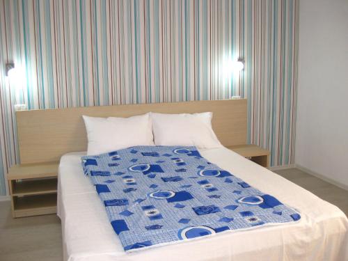 a bedroom with a bed with a blue blanket on it at Vila Azul in Eforie Nord