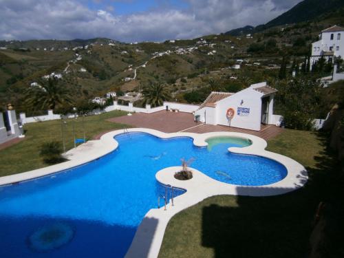 an overhead view of a large swimming pool with mountains in the background at Bella Vista in Frigiliana