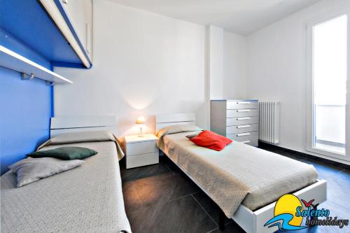 レウカにあるSH-Salento Luxury Apartment Giuseppeのベッドルーム1室(ベッド2台、ランプ付きデスク付)