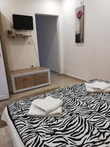 a bedroom with a zebra print bed with two pillows on it at Rooms and Apartments Milana in Bar
