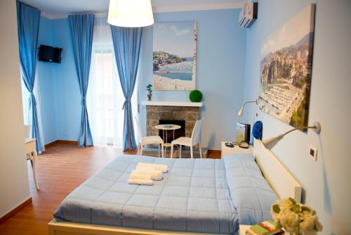 una camera blu con un letto e un tavolo di I Delfini ad Agropoli