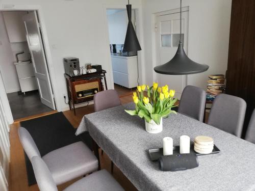 a kitchen with a table with yellow flowers on it at Kwatery u Eve in Dziwnów