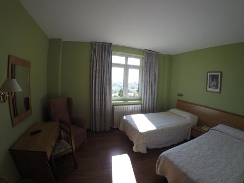 a hotel room with two beds and a window at Dunas de Oyambre in Comillas