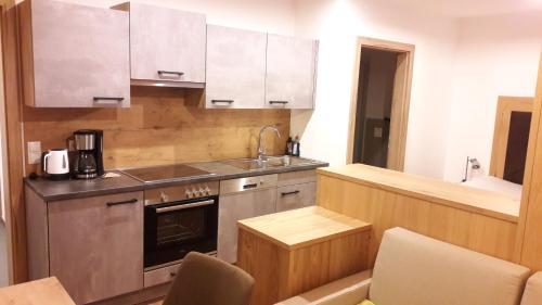 a kitchen with a sink and a stove at Die Atempause - appartements in Flachau