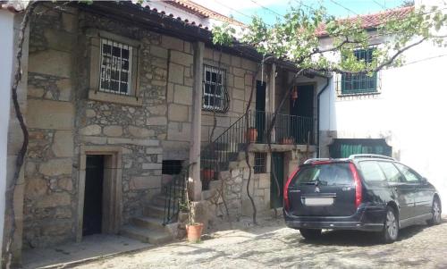 um carro estacionado em frente a um edifício de pedra em Quarto das Lamparinas em Ponte de Lima