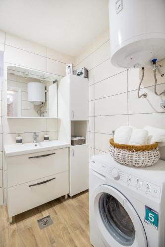 a white laundry room with a washing machine and a sink at Olive Garden in Ston