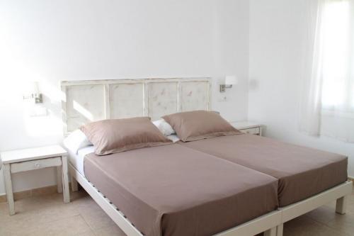 1 dormitorio con 1 cama grande y 2 mesas en Es Daus - Formentera Break, en Es Pujols