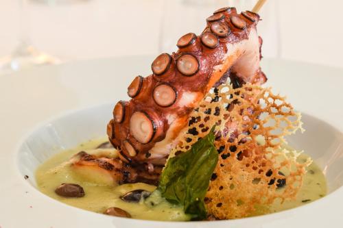 a plate of food with a crab on a stick at Hotel Villa Garuti in Padenghe sul Garda