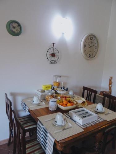 a table with a bowl of fruit and a clock at Clock's House in Fiumicino
