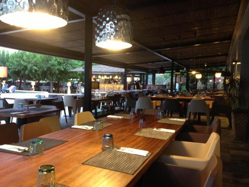 a restaurant with a long wooden table and chairs at Hostal SolFina in Palafolls