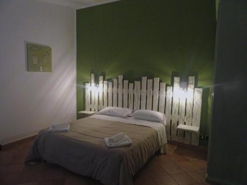 a bedroom with a large bed with green walls at Clock's House in Fiumicino
